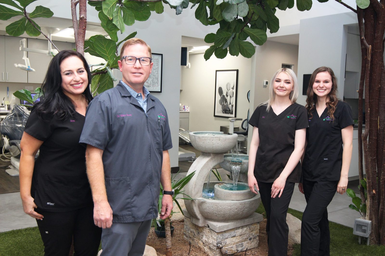 Dr. Brown and the Goodman Dental Care team beside the waterfall